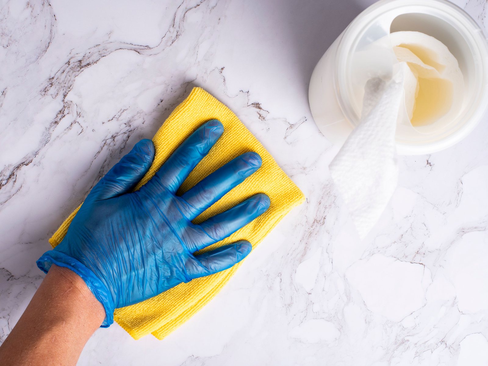 Gloved hand wiping a marble countertop